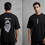 Back and front view of a premium black drop shoulder cotton t-shirt featuring 'Musafir' Arabic calligraphy and a traditional keffiyeh graphic.