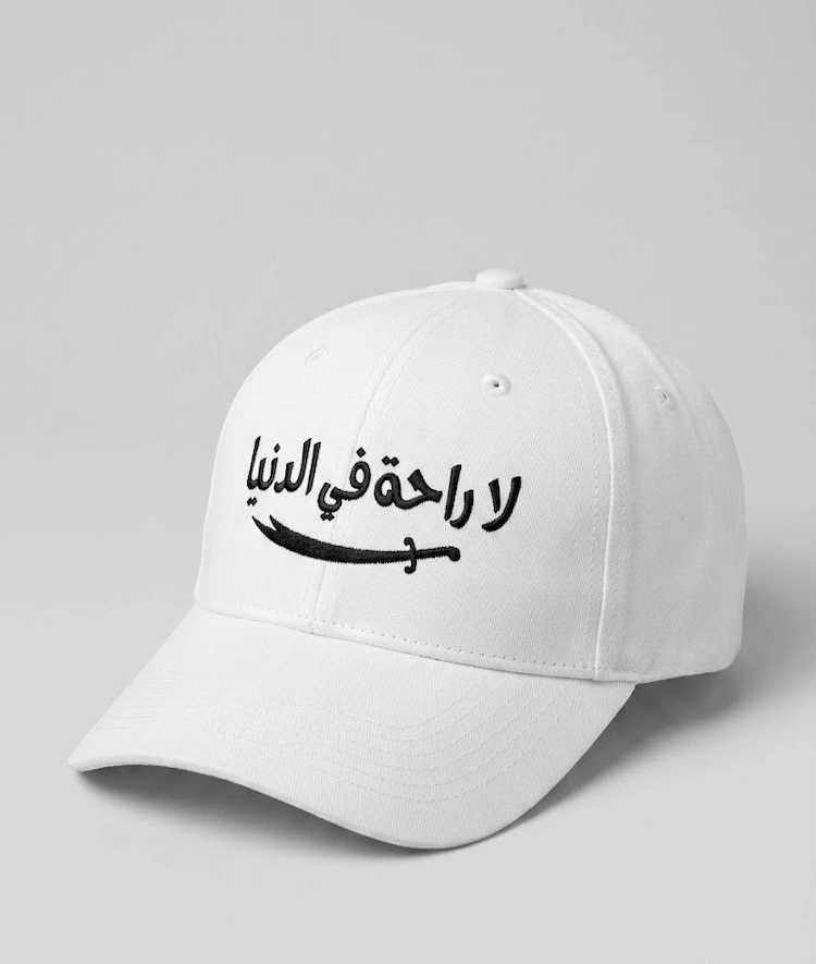 white-islamic-arabic-calligraphy-cap-la-raha.jpg Premium white cap featuring Arabic calligraphy La Raha Fi Al Dunya with sword embroidery.